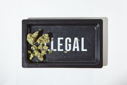 "ILLEGAL" Rolling Tray with Weed Nuggets, contrasting the flower with its legal status.