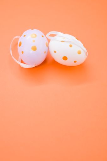 A closeup shot of decorative Easter eggs on an orange surface - copy space