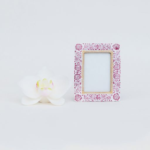 A beautiful photo frame and decorative flower on a white background