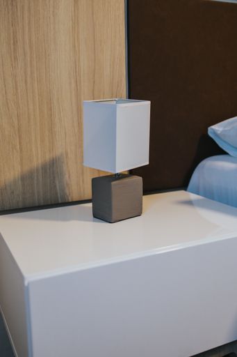 A vertical shot of a modern lamp on a bedside table in a room