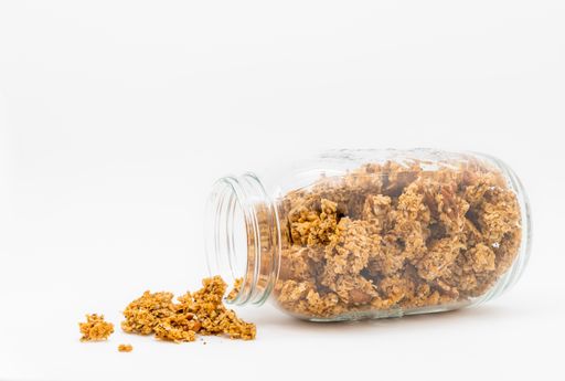 A closeup shot of a glass jar with granola made from oats and chia seeds isolated on white background