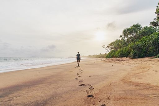 The footprints of a lonely male walking along the scenic sandy beach on a gloomy day, relaxation and harmony with nature