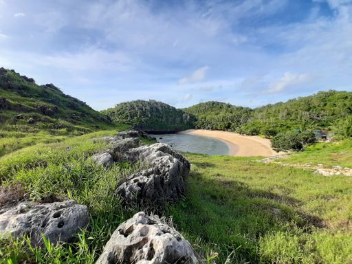 High angle view from a hill top on the lagoon sand beach called Pantai Kasap, surrounded from mountains and rain forest on Java, Indonesia
