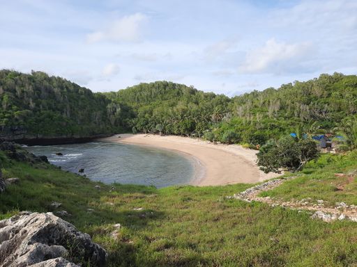 High angle view from a hill top on the lagoon sand beach called Pantai Kasap, surrounded from mountains and rain forest on Java, Indonesia
