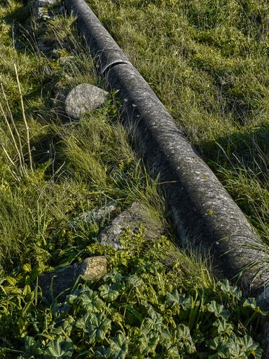 A top view of a pipe in nature with stones alongside