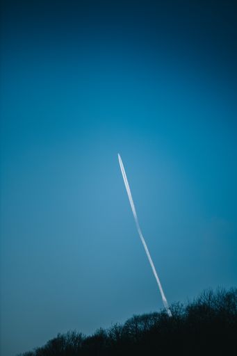 A beautiful shot of an airplane condensation trail going up on a blue sky