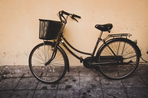 A black old fashioned bicycle against the wall parked in the street of Hanoi, Vietnam