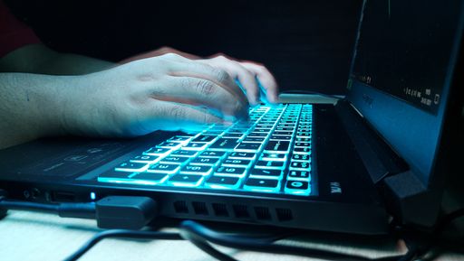 A selective focus shot of a man typing on a laptop keyboard - cybersecurity concept
