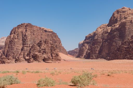 A landscape of rock formations in Wadi Rum desert under the sunlight and a blue sky in Jordan