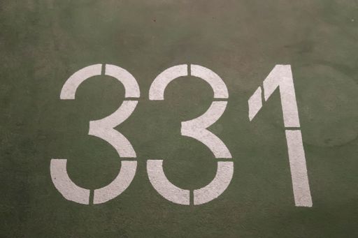 A high angle shot of numbers painted on the asphalt and cement on a road
