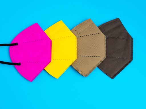 A closeup of colored reusable masks on a blue background, Copy space