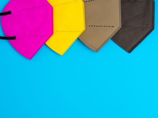 A closeup of colored reusable masks on a blue background, Copy space