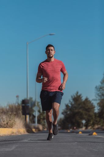 A vertical shot of a Hispanic male doing exercises outdoor