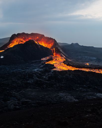 A view of Fagradalsfjall volcano crater in Iceland, with a vibrant orange hue emitting from the lava