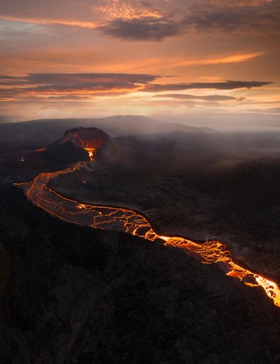 A stunning view of the eruption of Fagradalsfjall volcano in Iceland, with a vibrant orange hue emitting from the lava