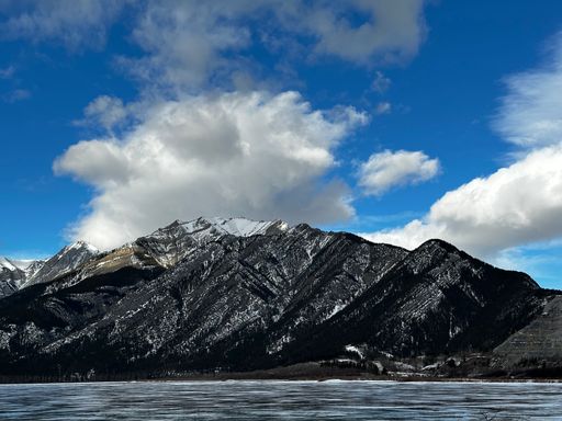 The beautiful rocky mountains against the background of the cloudy blue sky. Canada.