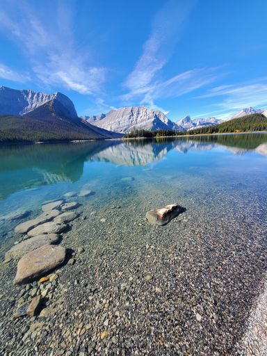 A scenic view of a lake situated amongst tall mountains
