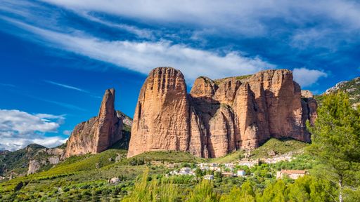 A scenic view of the famous rock formations of Mallos de Riglos in Spain underwispy sky background
