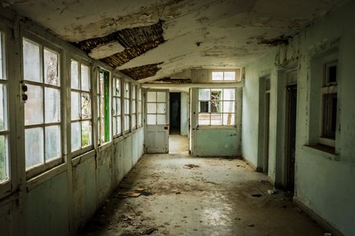 The hallway of an abandoned hospital building with peeling walls in Amiantos, Cyprus