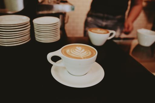 A closeup shot of a beautifully made cappuccino with flower foam art