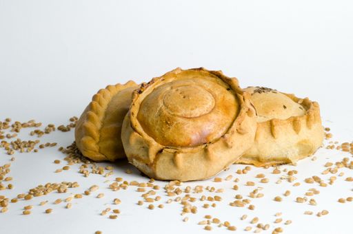 A closeup shot of the Tatar mini pies with meat and potatoes on a white background