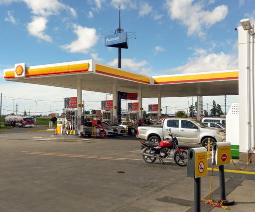 Commercial Center. Shot of cars at the Shell gasoline station beside the highway. Sunny day. Copyspace