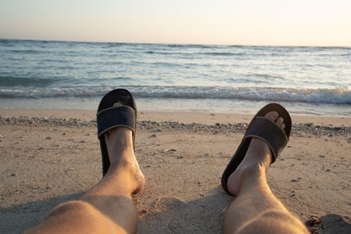 A Close up photo of Young Legs at a beautiful tropical Beach. Relax Barefoot in the Sand by the ocean.