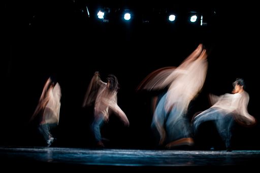 An abstract image of hip-hop dancers performing on a stage