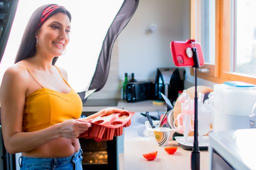 A young Latin-American woman cooking and shooting a blog - the concept of blogging