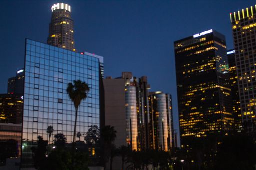 A low angle shot of modern business buildings in the middle of the city during nighttime