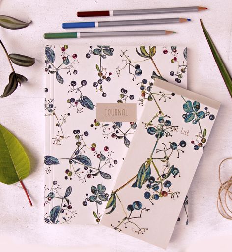 A top view shot of Notebooks, pencils, and plants on the white background.