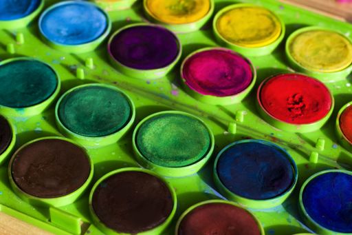 A closeup of a watercolor palette on the table under the lights