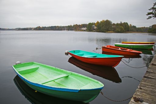 The old wooden boats near the beach of Trakai Gavle lake, Lithuania. Autumn and fall time.