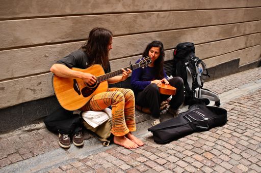 Two backpackers busking for money on the streets of Stockholm, Sweden.