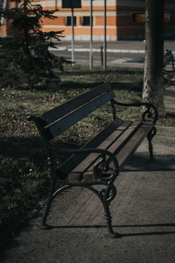 A vertical shot of a wooden bench in the park