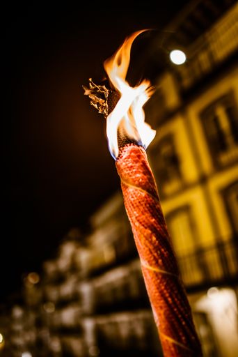 A vertical shot of a burning torch at night