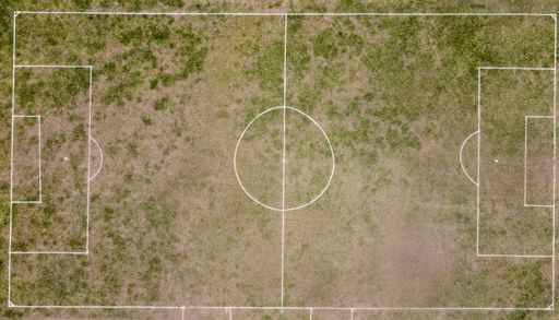 A top view on a soccer pitch with deteriorated grass surface