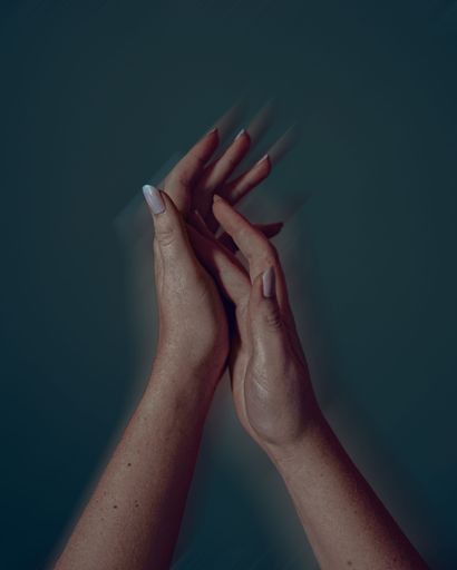 A vertical shot of female hands against dark background