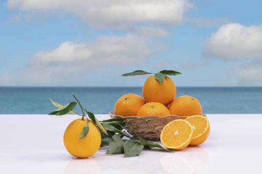 Fresh oranges in a wicker basket with leaves on an out of focus background. selective focus. vitamin and healthy food concept.