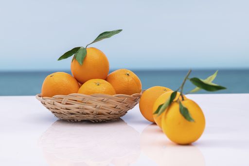 Fresh orange in a wicker basket with leaves on an out of focus background. selective focus. vitamin and healthy food concept.