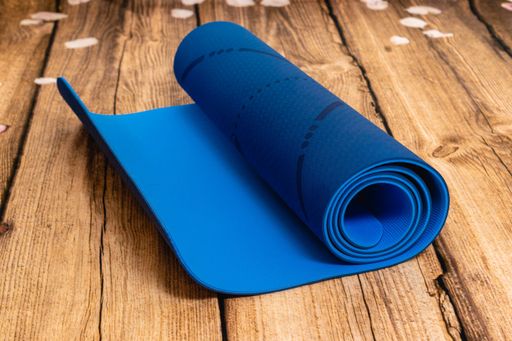 A closeup shot of a blue yoga mat on a wooden surface