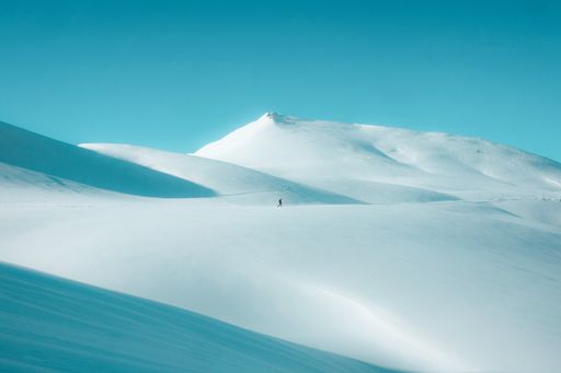 A beautiful view of the field covered in snow with the mountain in the background