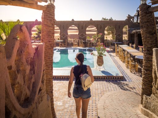 A female going to the swimming pool of an oasis in the desert