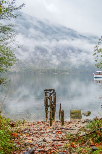 A port on a lake near a mountain surrounded by mist