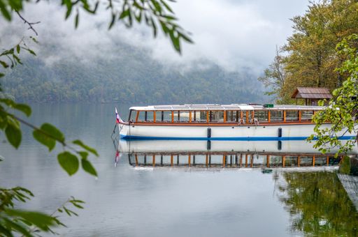 A boat docked on a lake port near a cottage