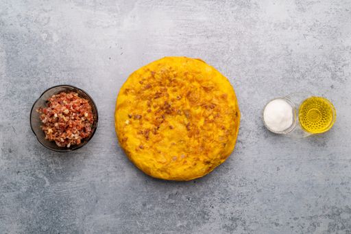 An overhead shot of an Iberian ham omelet with the ingredients next to it