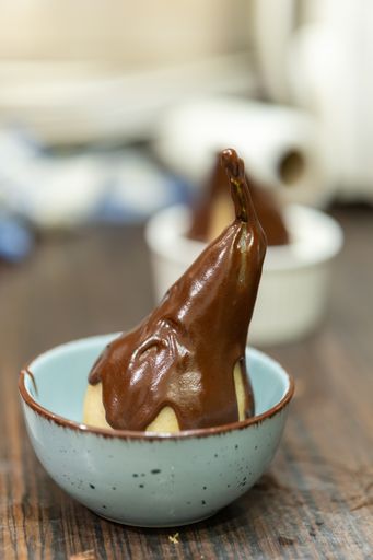 A vertical shot of chocolate glazed candy in a bowl on the table