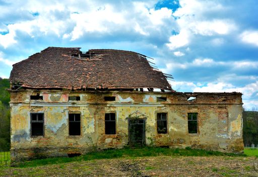 A view of an old abandoned ruined house under a blue sky