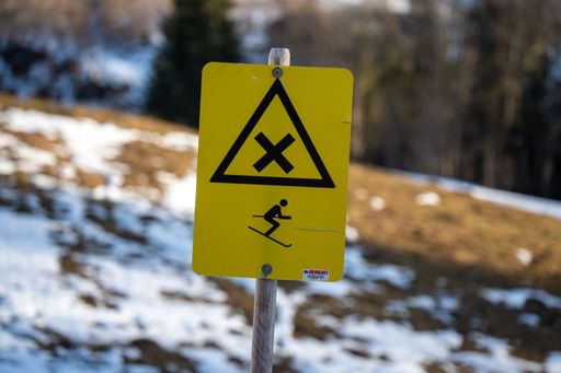 A closeup of a danger ski sign on ski slope in winter