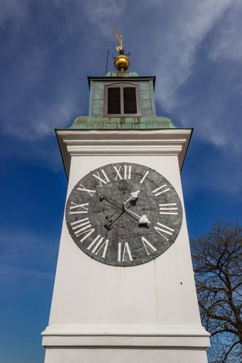 A vertical shot of a tower with a clock in Serbia under the blue sky